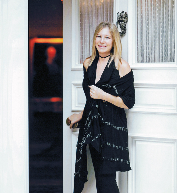 Streisand stands at the entrance of her new home, welcoming us in.